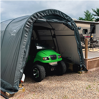 A ShelterLogic round-top garage with a tractor inside.