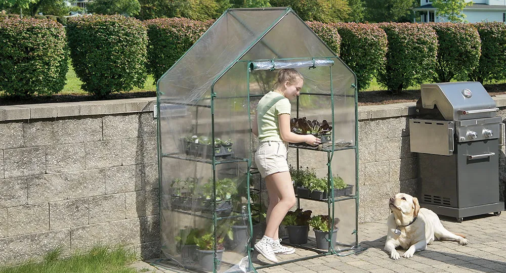 woman watering plants in a raised bed garden
