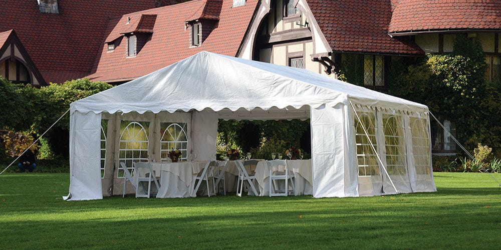 a party tent set up in front of a mansion