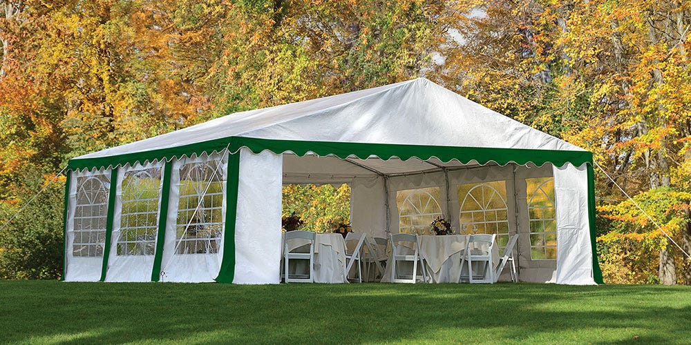 a green and white party tent set up in a park