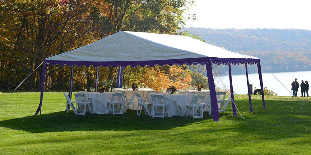 A party tent set up for an outdoor event held near a lake